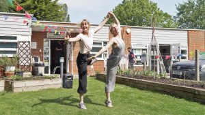 Photo of two girls dancing together on grass