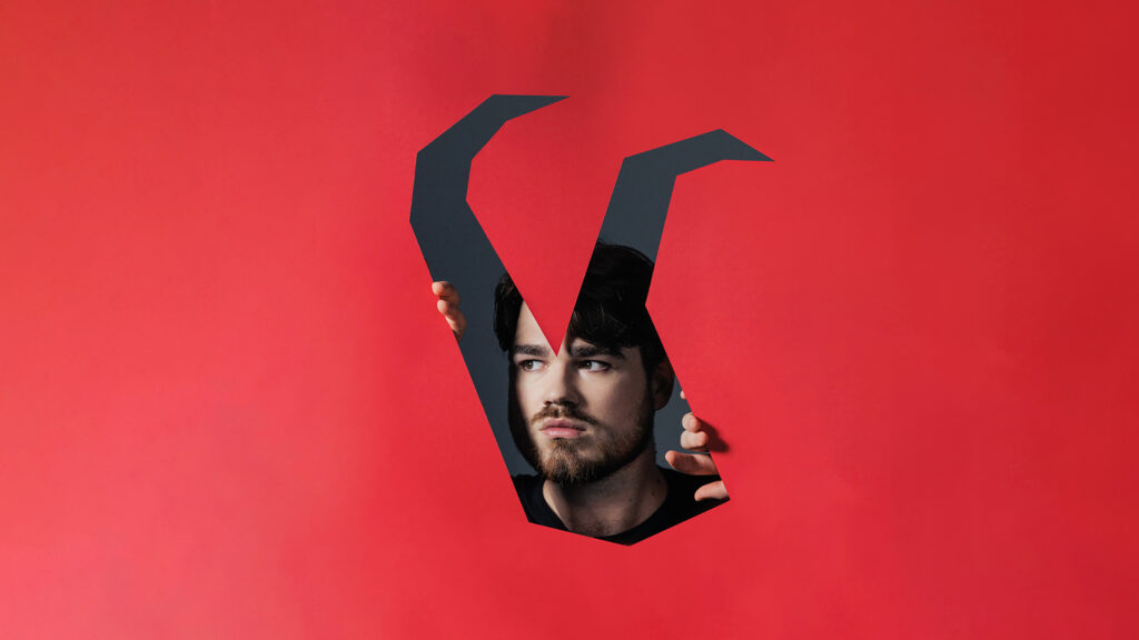 Artwork for English Touring Opera The Rake's Progress, a man is looking through a red box in a deer head shape